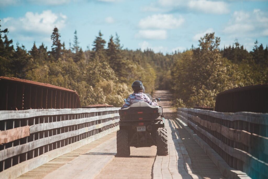 A couple on an ATV crosses a bridge