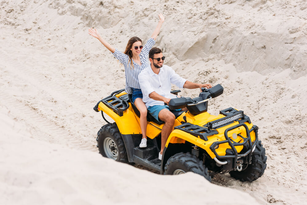 A couple traveling in the desert on an ATV