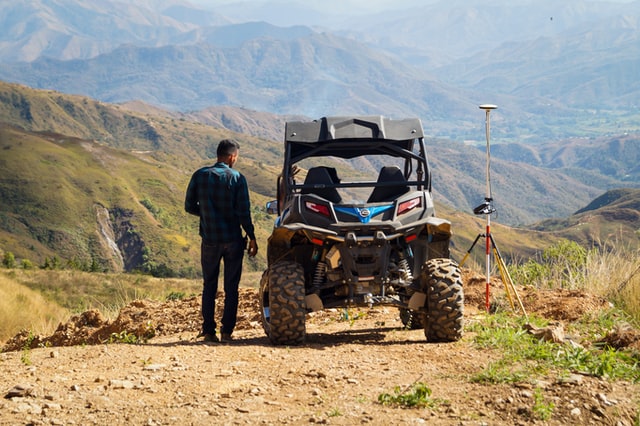 A man looks at a view near an ATV