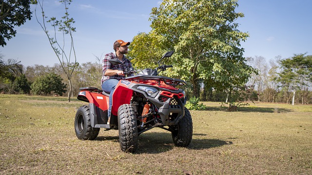 A man with a hat rides a red ATV
