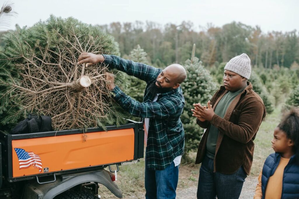 Black man putting Christmas tree in back of AT