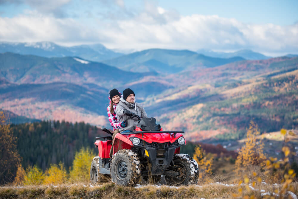 Couple on four-wheeler ATV in mountains