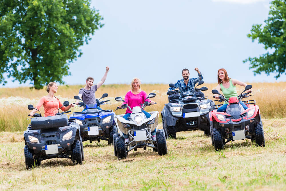 Friends driving off-road with quad bike or ATV
